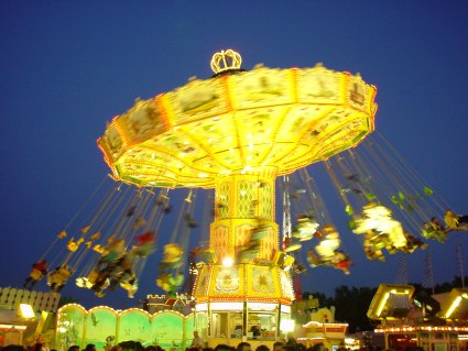 Ein beleuchtetes Karusell am Volksfest in der Nacht