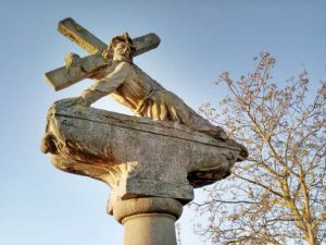 Eine Sandsteinfigur mit Jesus am Kreuz