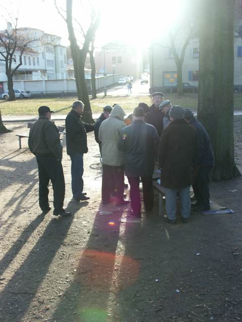 ein paar Männer stehen im Park und diskutieren