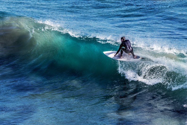 Ein Mensch surft auf der Höhe einer Welle