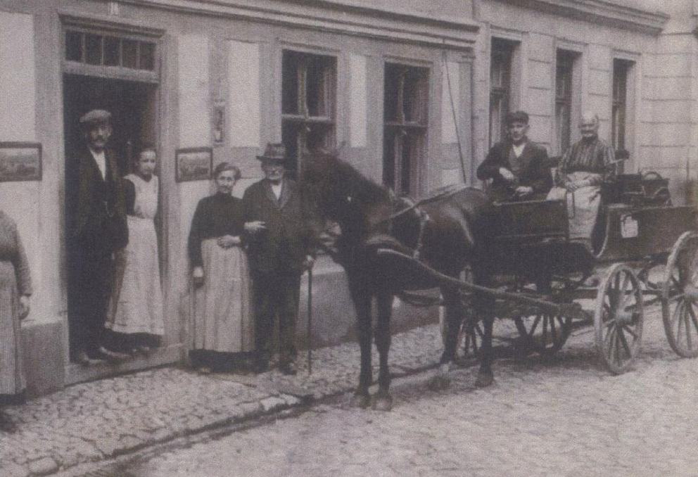 Ein historisches Bild in schwarz-weiß mit einer Familie und einem Pferdewagen